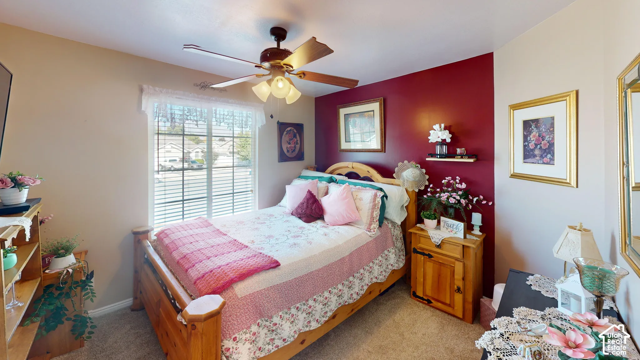 Carpeted flooring, a window with blinds, a ceiling fan with integrated lighting, and a built-in wall shelf