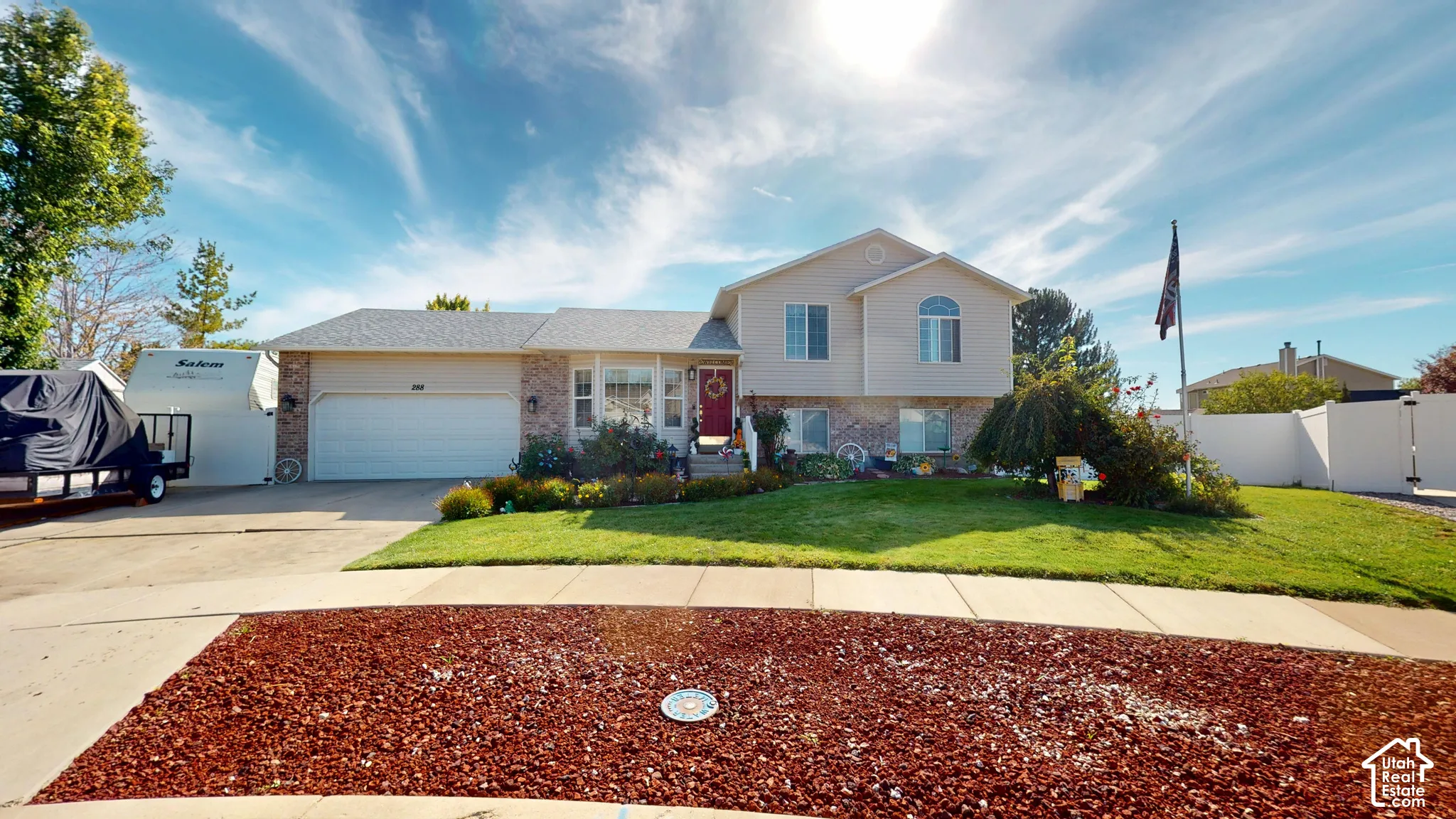 Split-level residence featuring a brick and siding exterior, an attached two-car garage, and a manicured front lawn