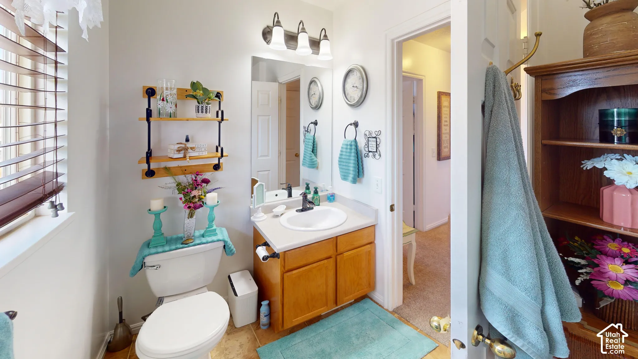 Vanity with integrated sink, wood-finish cabinetry, and wall-mounted mirror