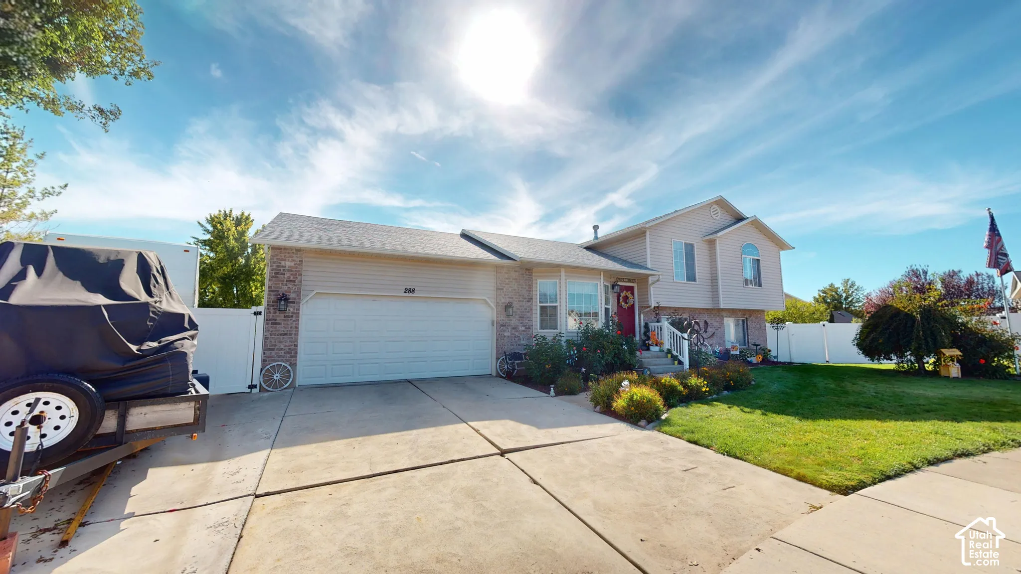 Split-level residence featuring brick and siding exterior, an attached two-car garage, and a concrete driveway