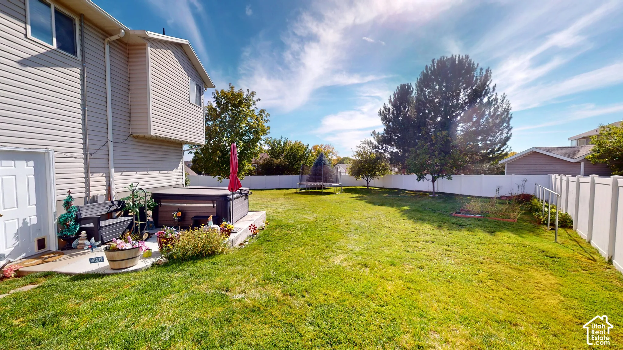 Expansive backyard with a large lawn, privacy fencing, and mature trees