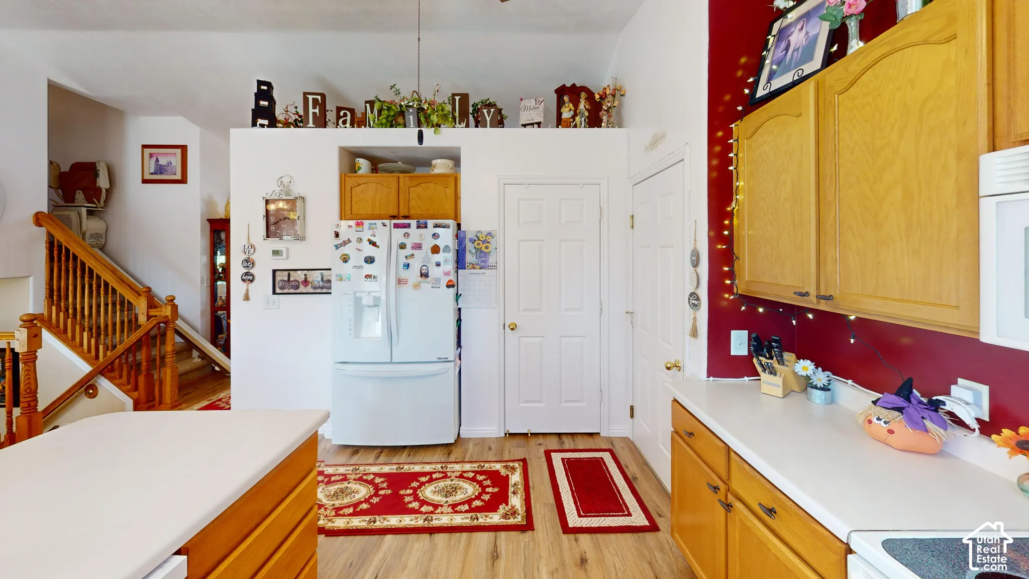 Wood-finish flooring, white countertops, and wood cabinetry