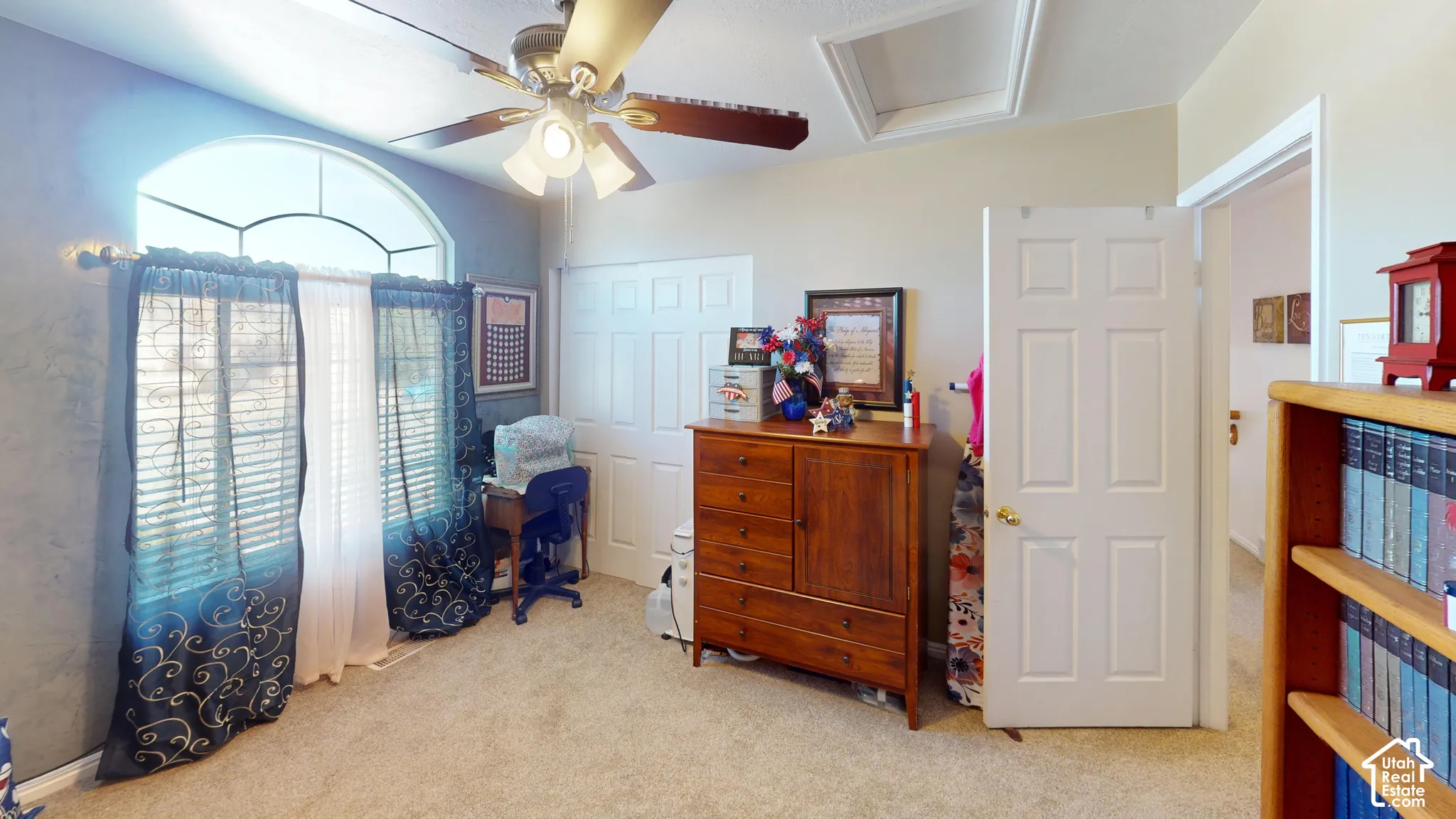 Arched window with upper transom, vaulted ceiling, built-in ceiling fan, and carpeted flooring