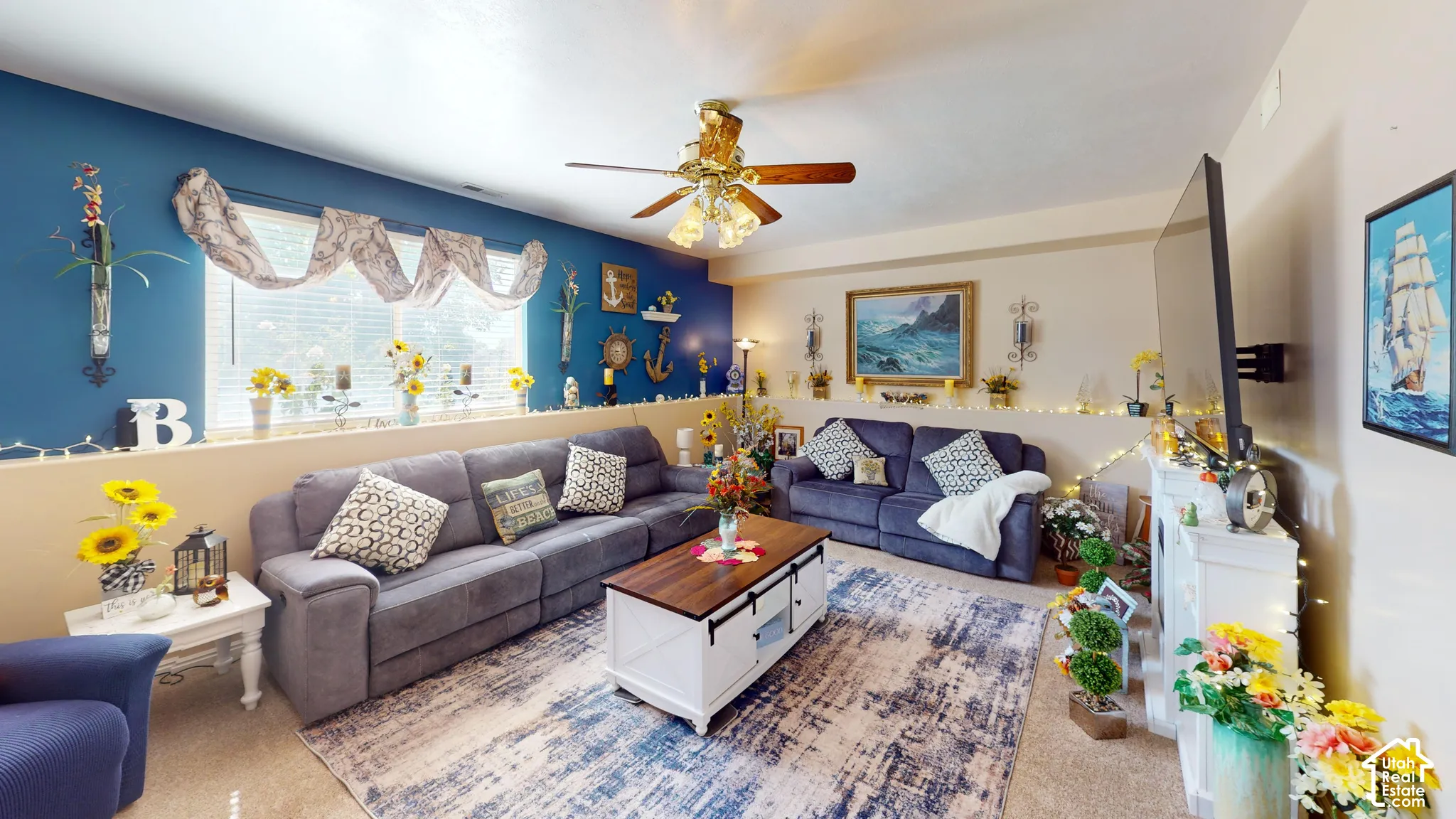 Wall-mounted television with bracket, ceiling fan with light fixture, and window with draped valance