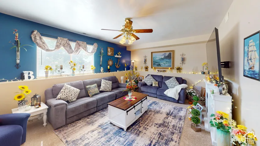 Wall-mounted television with bracket, ceiling fan with light fixture, and window with draped valance