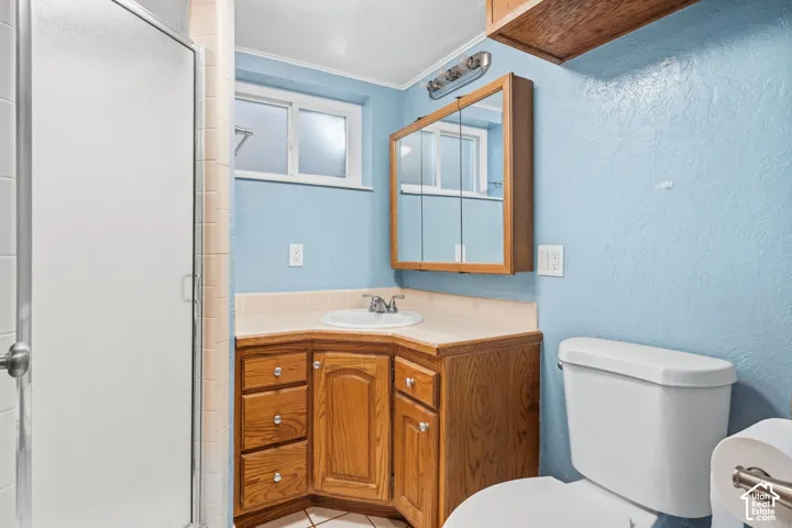 Corner vanity with wood-finish cabinetry, integrated sink, and wall-mounted medicine cabinet