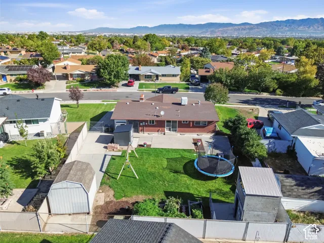 Expansive backyard featuring a manicured lawn, concrete patio, and mature trees