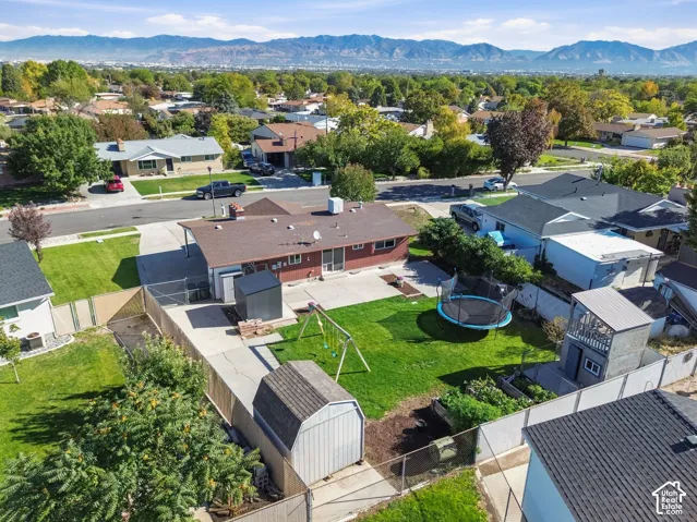 Expansive backyard featuring a manicured lawn, established landscaping, and perimeter fencing