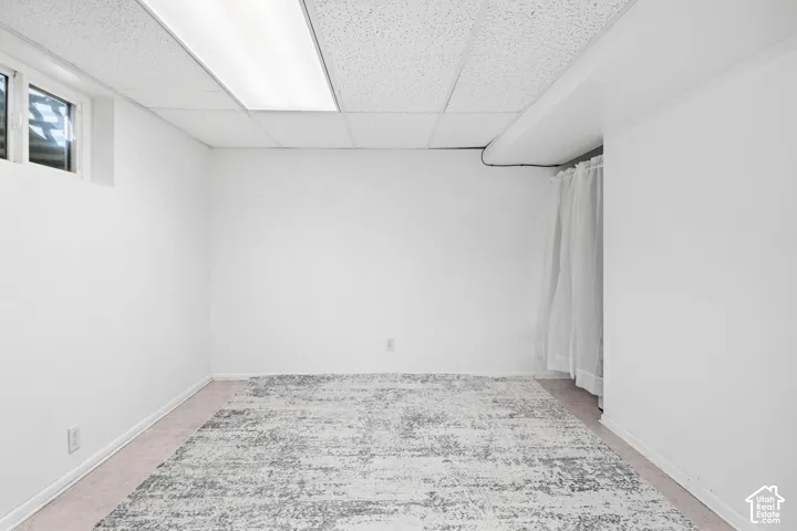 Wall-to-wall carpeting with light-colored walls and a drop ceiling