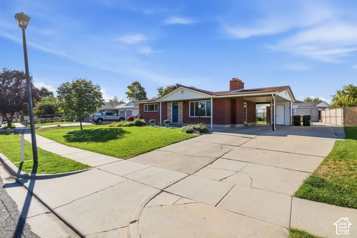 Brick exterior with a carport and an extended concrete driveway