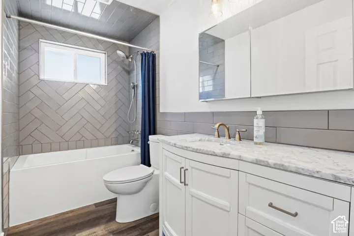 Bathroom featuring a white vanity with a stone countertop, a bronze-finish faucet, and a large mirror