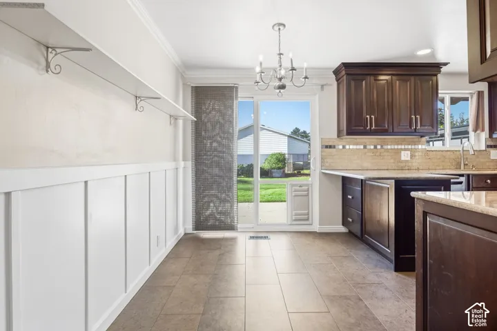 Board and batten wainscoting, integrated shelving, tile flooring, dark wood cabinetry, and a sliding glass door