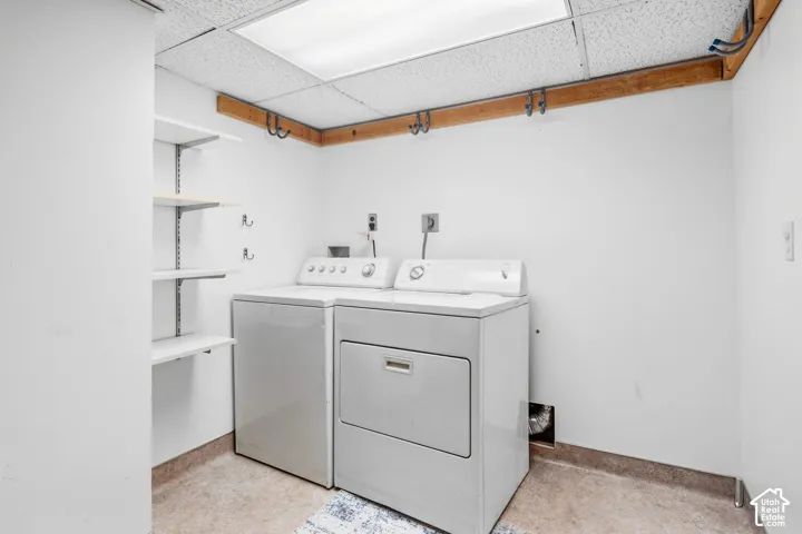 Dedicated laundry area featuring white walls, textured ceiling, and built-in shelving