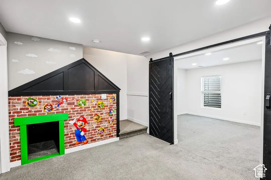 Family Room in basement leading to bedroom with farm-stlye door
