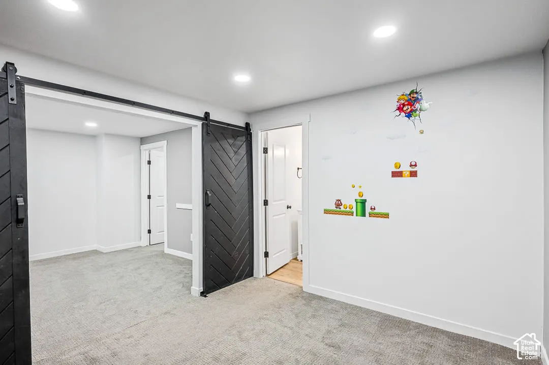 Family Room in basement leading to bedroom with farm-stlye door