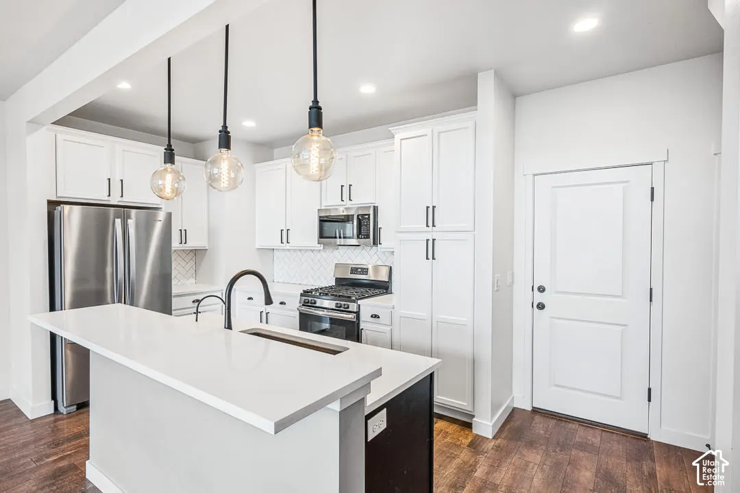 Kitchen featuring white cabinetry, central island & stainless steel appliances
