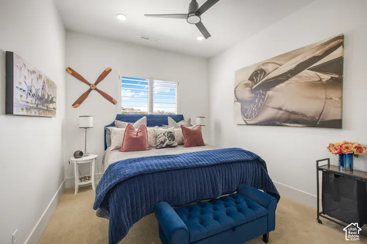 Recessed lighting, ceiling fan, window with plantation shutters, light-toned carpeting, and crisp white walls