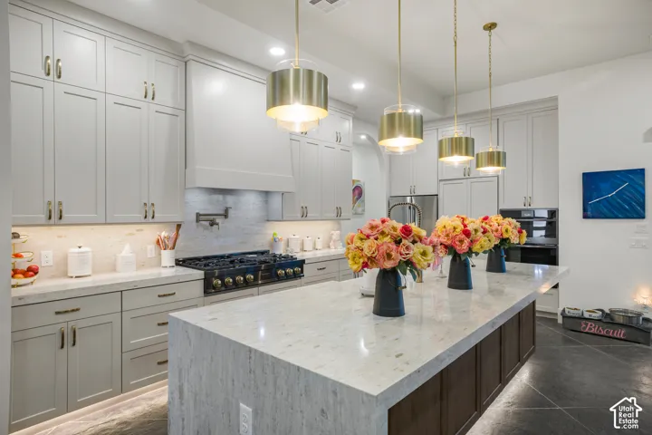 Expansive kitchen island with a light-toned countertop, complete with four pendant lights overhead