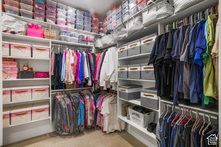 Custom closet system featuring multiple hanging rods, extensive shelving, and integrated storage compartments