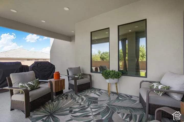 Covered patio with recessed lighting, integrated stucco walls, and two vertical windows
