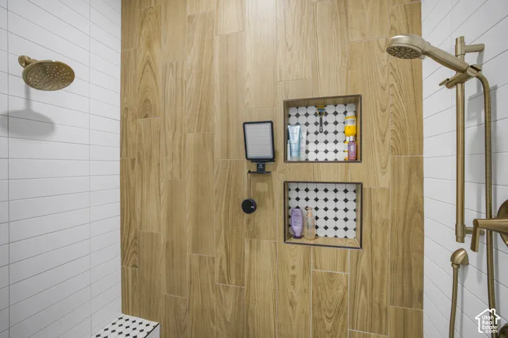 Wood-look tile shower wall, dual shower heads, built-in shower niches with mosaic tile, white subway tile