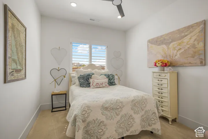 Recessed lighting, ceiling fan, window with plantation shutters, and light-tone carpeting