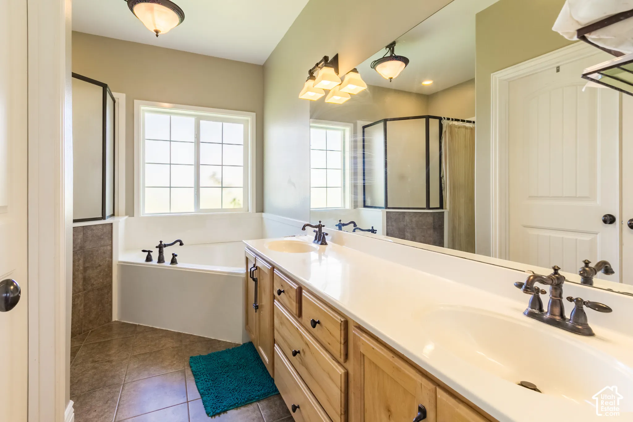 Dual vanity with integrated sinks, wood-finish cabinetry, and oil-rubbed bronze hardware