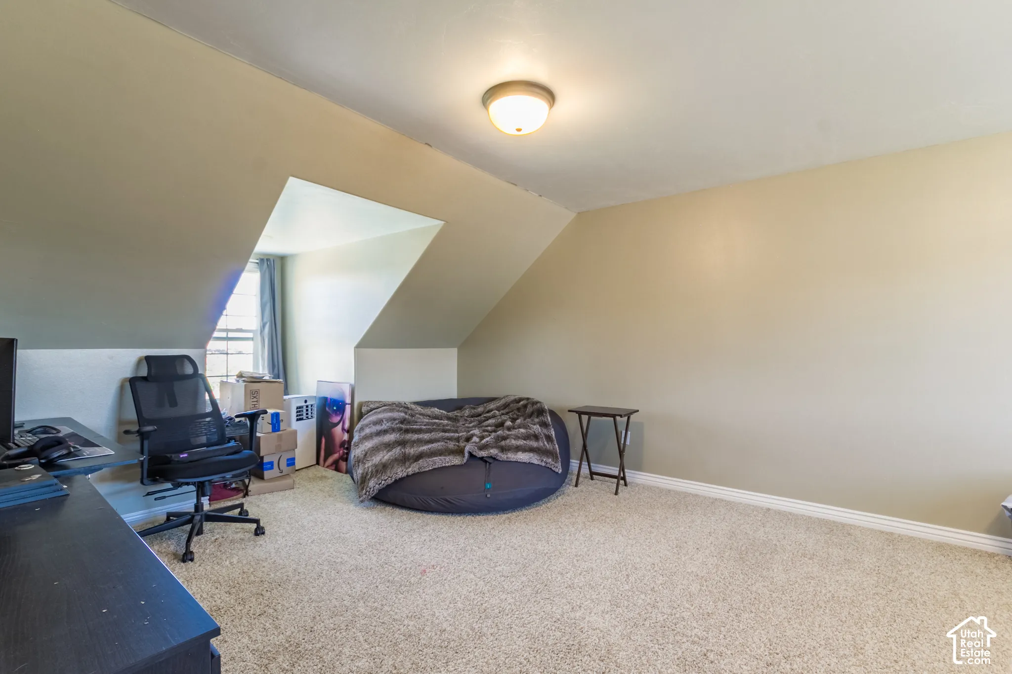Sloped ceiling lines, neutral wall paint, and a built-in window nook