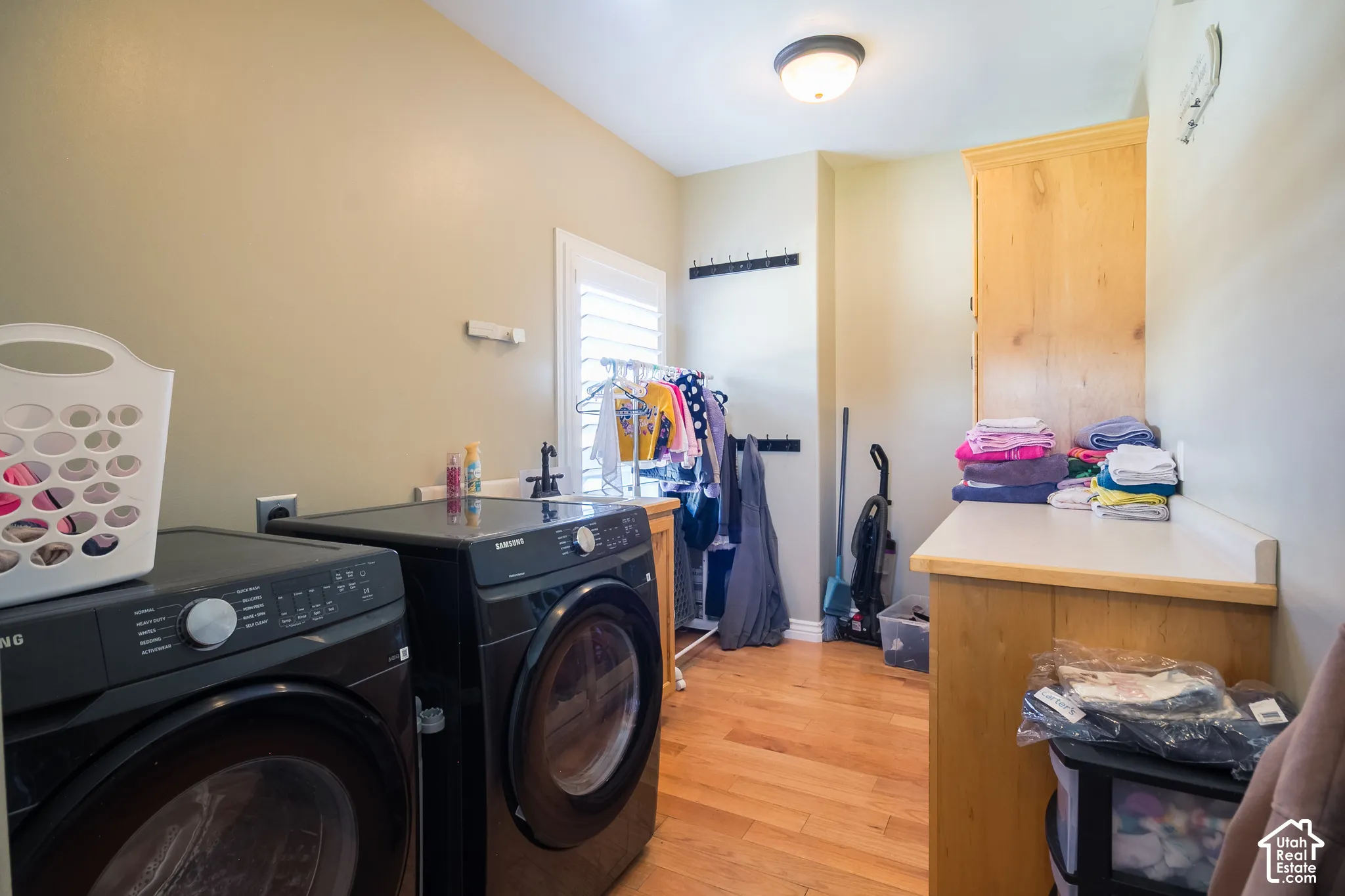 Hardwood flooring, built-in cabinetry, utility sink, counter space, and window with plantation shutters