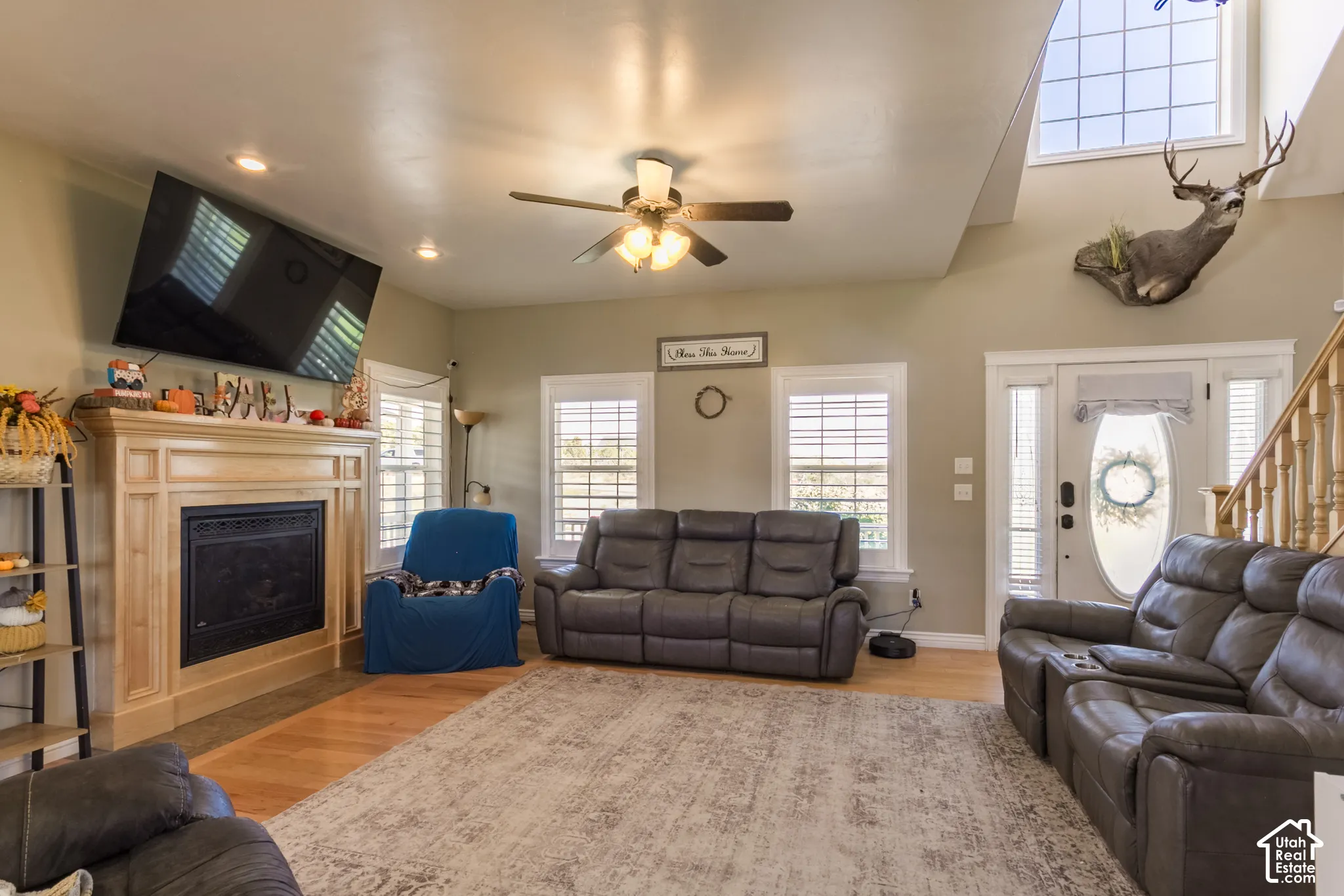 Wood-finish flooring, recessed lighting, ceiling fan, and a fireplace with a wood mantel