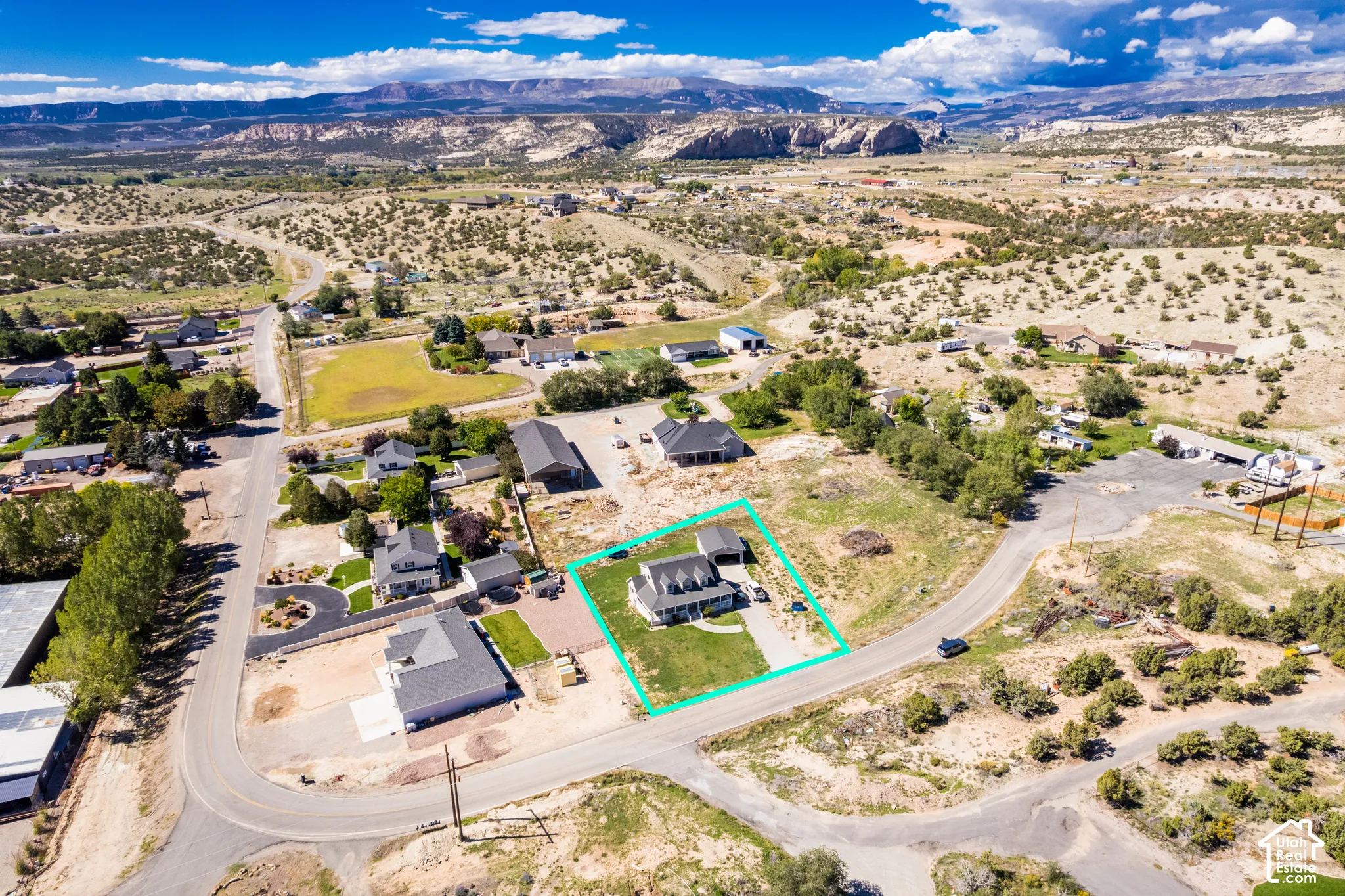 Expansive property with a large, manicured lawn, a concrete driveway, and mature landscaping