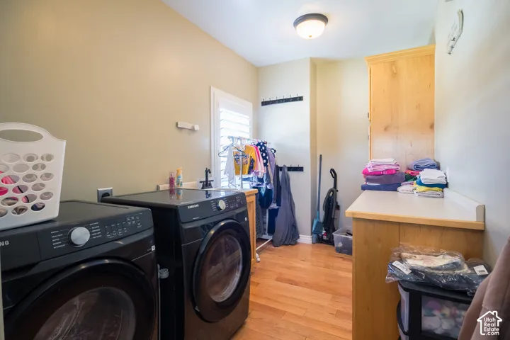 Hardwood flooring, built-in cabinetry, utility sink, counter space, and window with plantation shutters