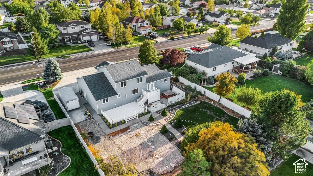Two-story residence with a brick exterior, white deck, and a fenced backyard featuring a manicured lawn