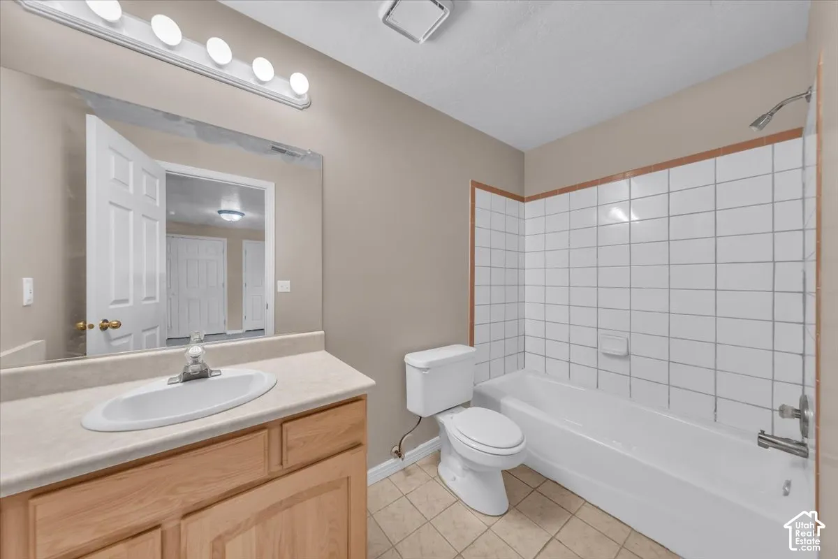 Full bathroom featuring a single vanity with wood-finish cabinetry, a white oval sink, and a chrome faucet