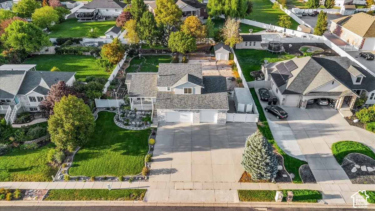 Property featuring a 3-car garage, RV area, established landscaping, and a fenced backyard