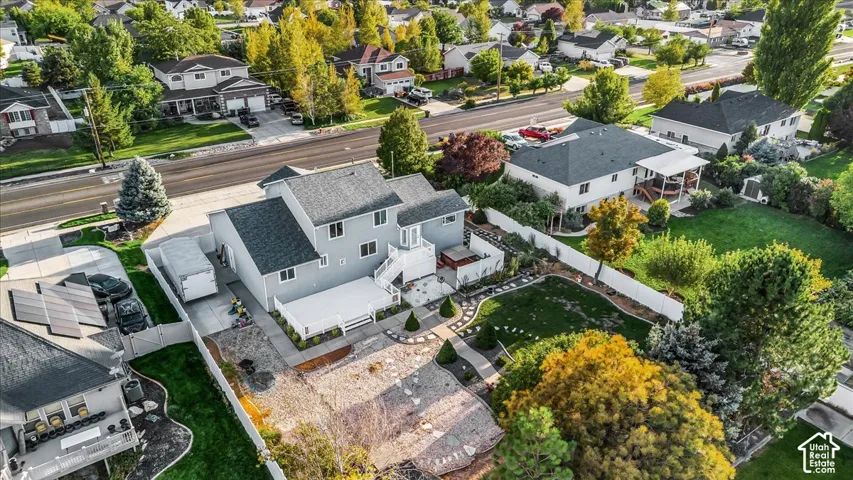 Two-story residence with a brick exterior, white deck, and a fenced backyard featuring a manicured lawn