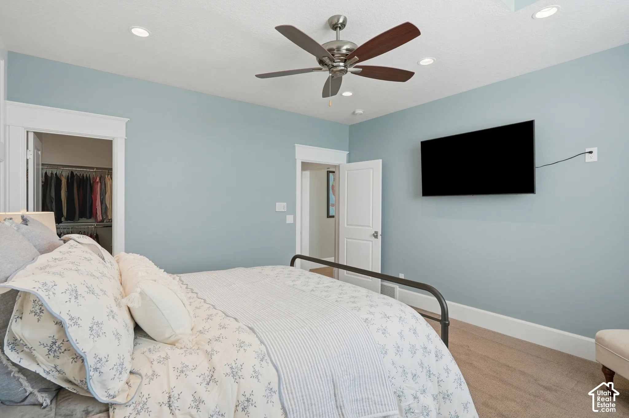 Recessed lighting, ceiling fan with wood-finish blades, carpet flooring, and white trim detailing