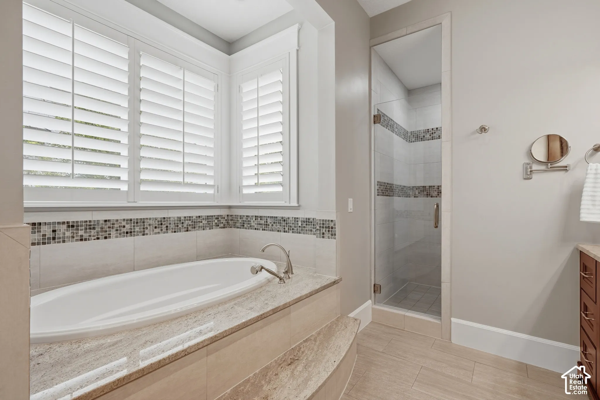 Soaking tub with a polished stone surround and decorative tile accent