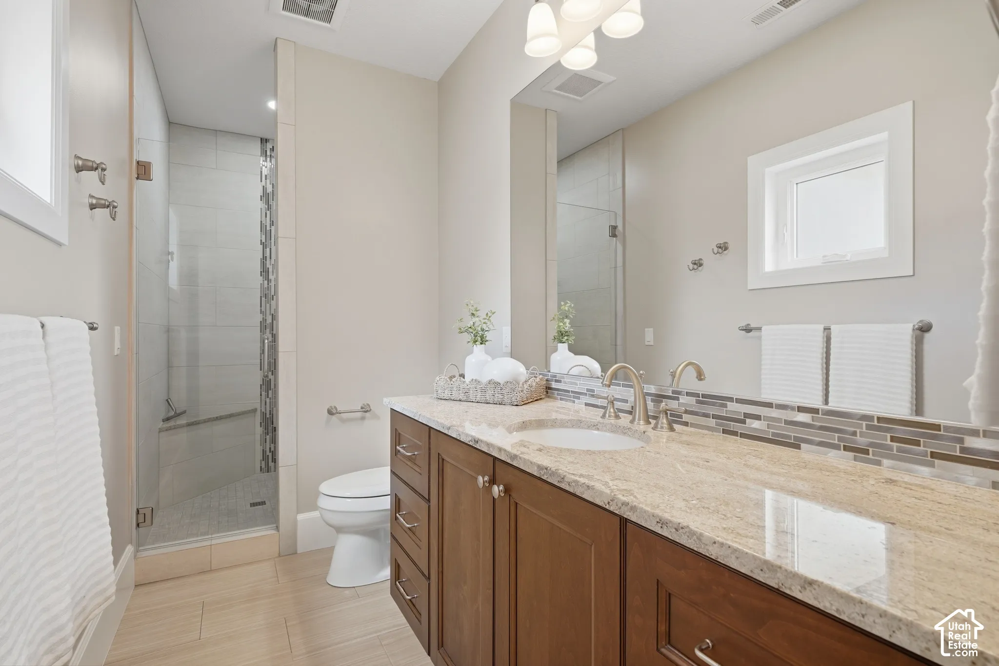 Double vanity with undermount sinks, stone countertop, and wood-finish cabinetry