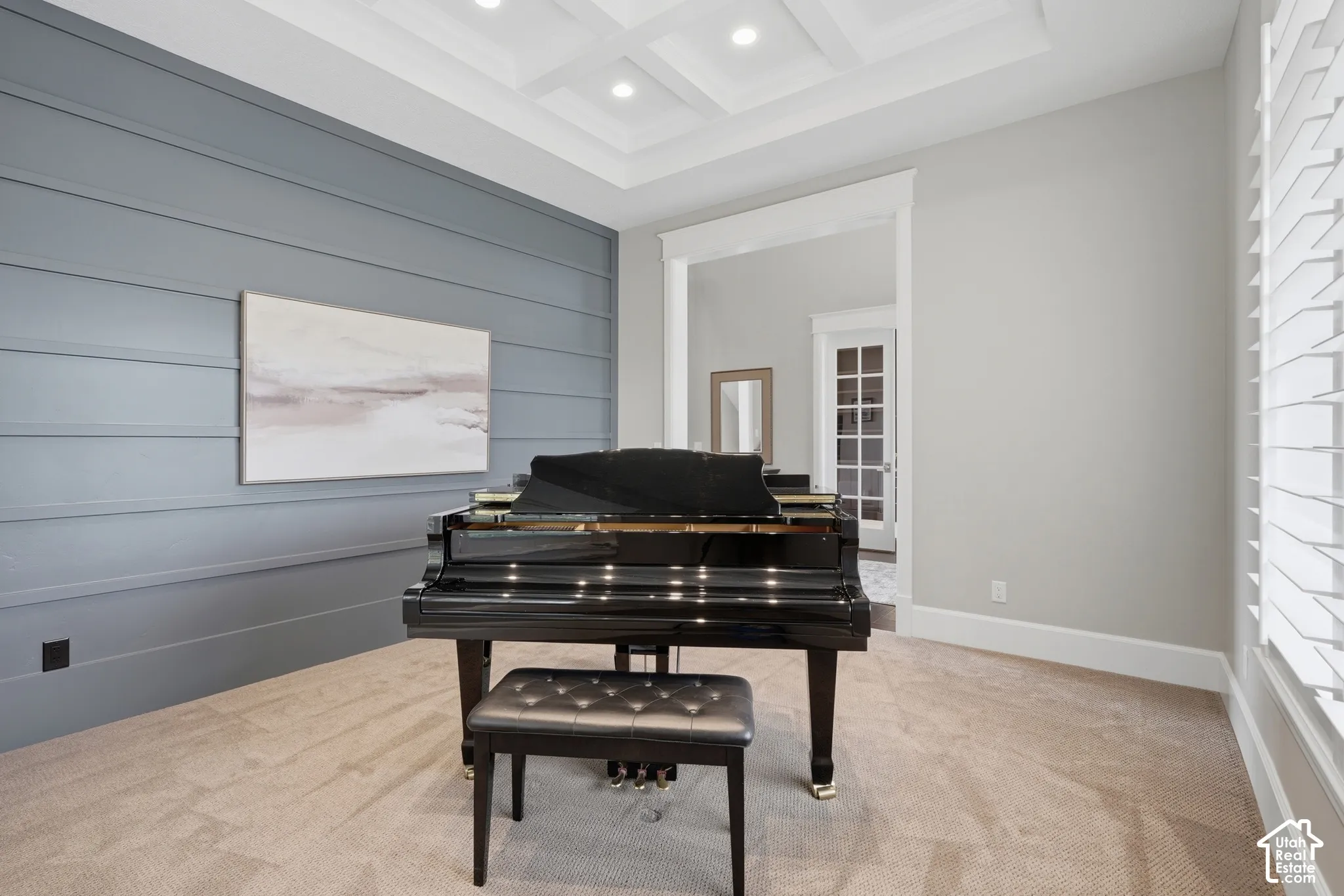 Coffered ceiling with recessed lighting, shiplap accent wall, white plantation shutters, and an arched entryway