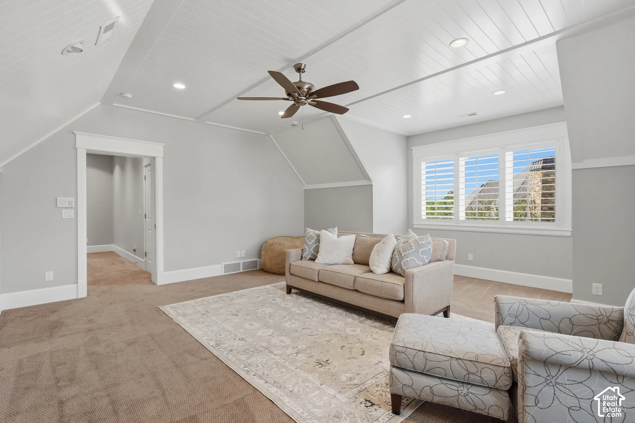 Recessed lighting, sloped ceilings, ceiling fan, carpeted flooring, and white window shutters