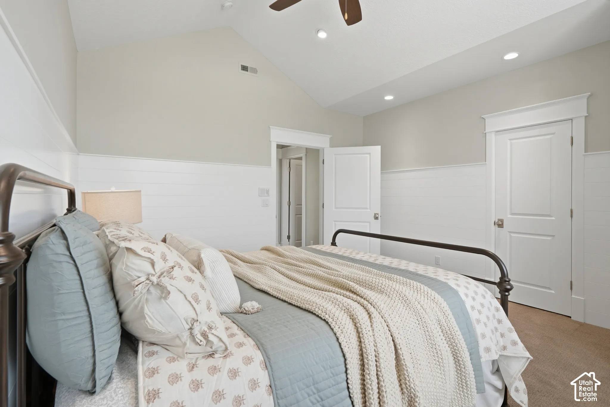 Vaulted ceiling with recessed lighting and ceiling fan, two paneled doors, and wall paneling