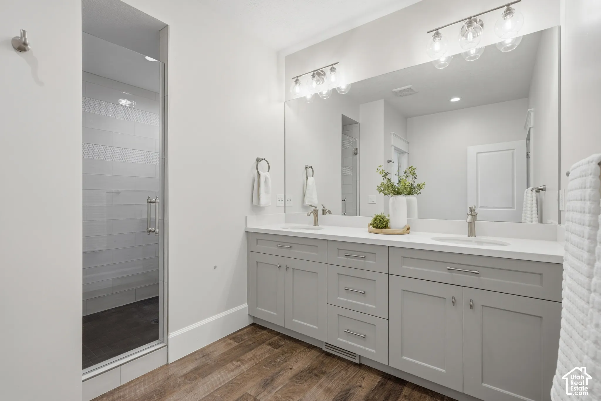 Dual vanity with light gray cabinetry, quartz countertops, and brushed nickel fixtures