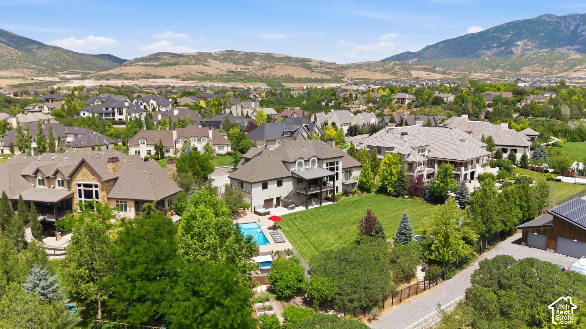 Expansive community featuring diverse architectural styles, mature landscaping, and mountain backdrops
