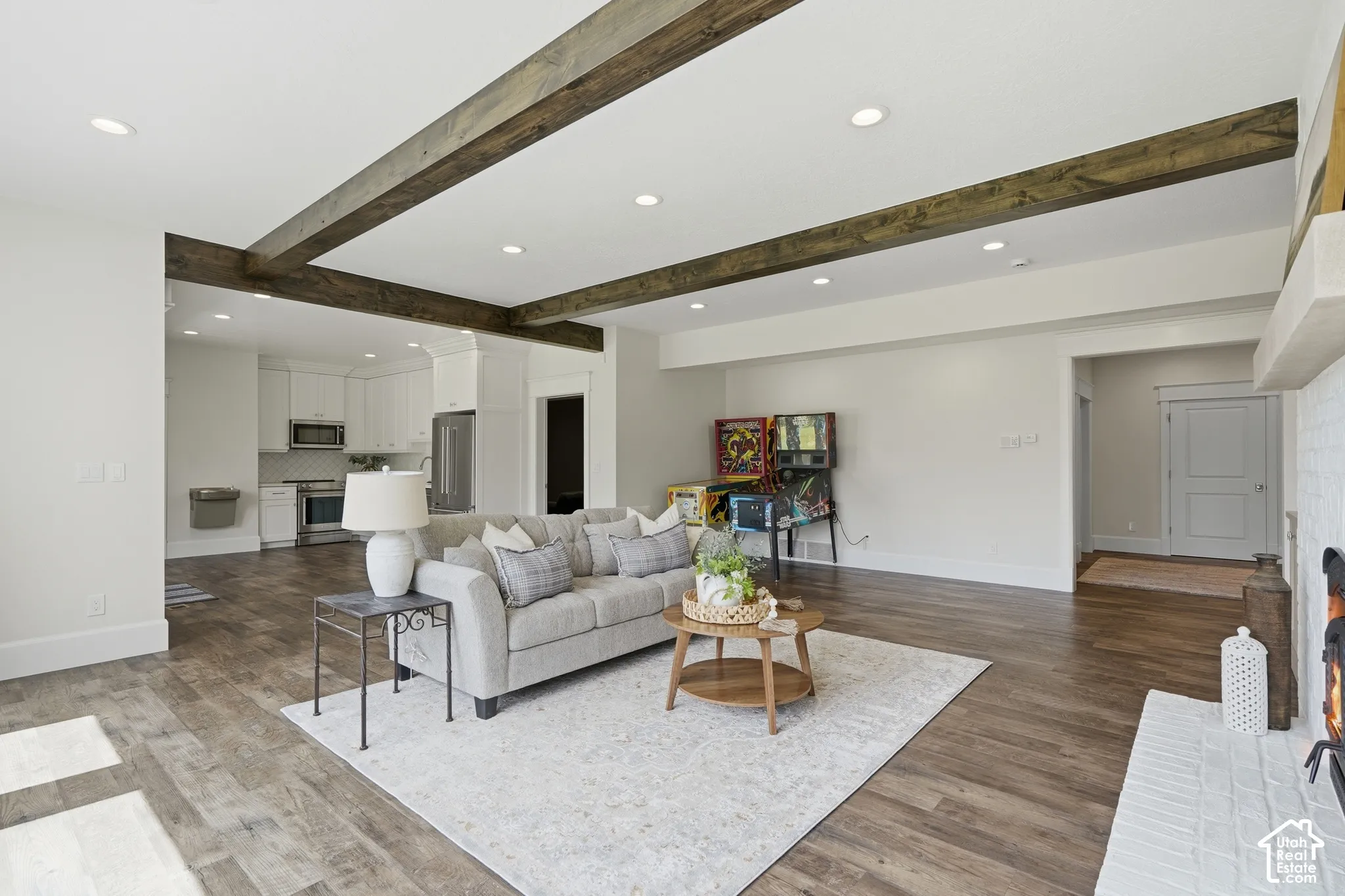 Living area featuring wood-finish flooring, recessed lighting, and exposed ceiling beams