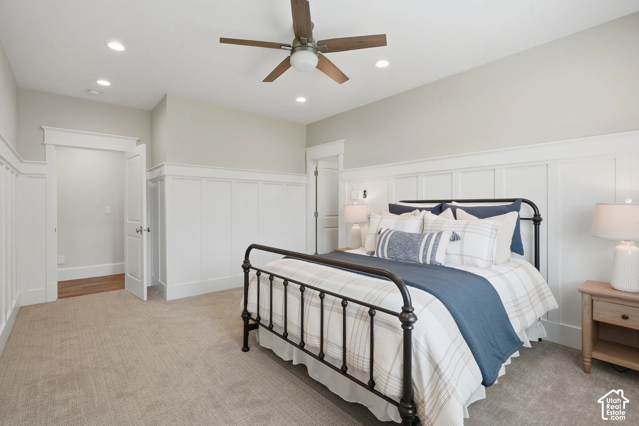 Recessed lighting, wood-finish ceiling fan, neutral wall tones, white wainscoting, and carpeted flooring