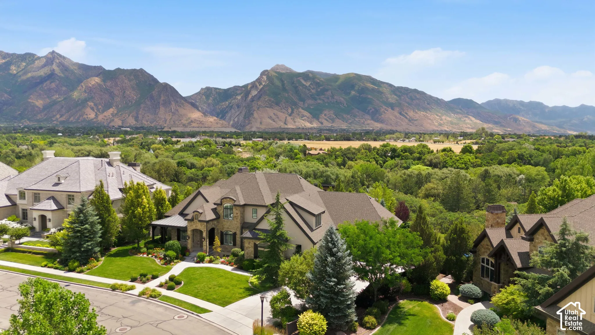 Stone and stucco exterior with dark shingle roof