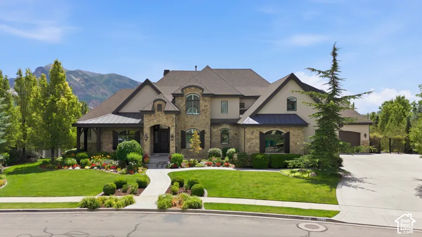 Stone and stucco exterior with multiple gables and a covered entry