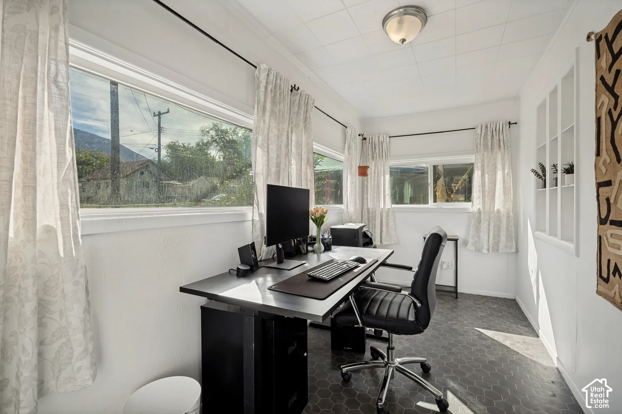 Hexagonal tile flooring, multiple windows, built-in shelving, and a semi-flush mount ceiling light