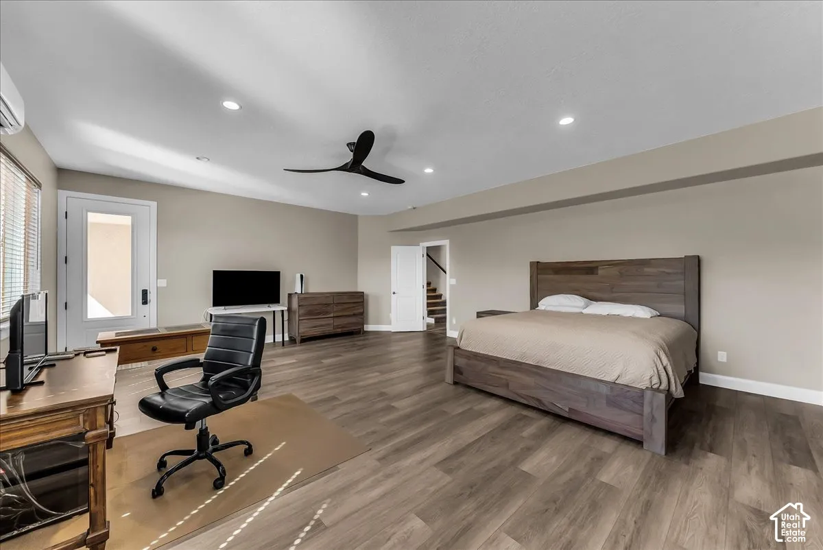 Spacious room featuring wood-finish flooring, recessed lighting, and a contemporary ceiling fan